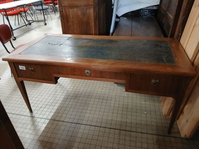 a wooden desk with a glass top in the middle of a room
