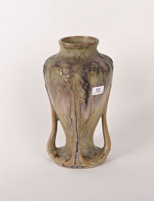 un petit vase muni d'une anse, posé sur une surface blanche