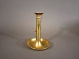 a gold candle holder on a table with a white background