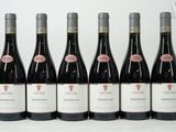 six bouteilles de vin sont alignées sur une table