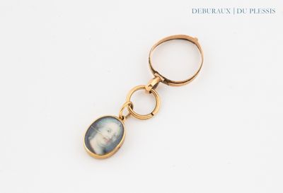 une image représentant un porte-clés en or orné du portrait d'une femme