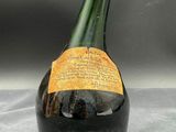 an old bottle of wine sitting on top of a table