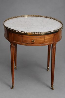 une table ronde avec un plateau en marbre et des pieds en bois