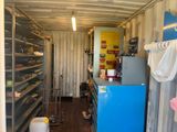 a room with a refrigerator and shelves in it