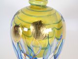 a yellow and blue glass vase on a white surface