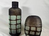 deux vases posés l'un à côté de l'autre sur une surface blanche