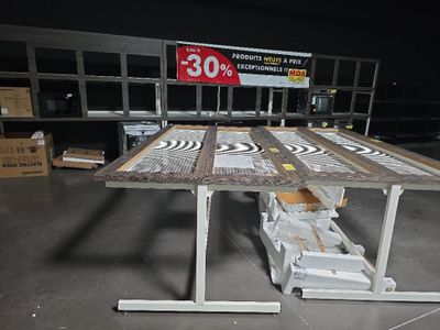 une table sur laquelle est posée une pancarte, dans un entrepôt