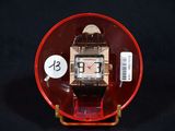 une petite assiette rouge sur laquelle est posée une montre