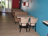 tables and chairs in a room with blue walls and wood flooring