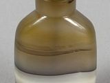 a small glass bottle with a brown and white stripe on it