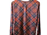 a red and blue plaid shirt hanging on a wooden hanger
