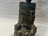 a statue of a bird sitting on top of a tree stump