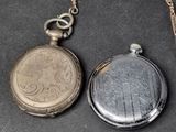 two pocket watches sitting next to each other on a table