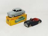 two toy cars sitting next to each other on a table