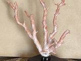 un vase noir orné d'un arbre blanc, posé sur une table en marbre