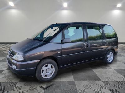 une photo d'un monospace gris garé dans un garage