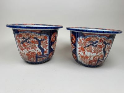 two blue and orange vases sitting on top of a white table