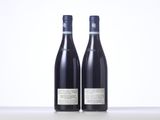 two bottles of wine sitting on top of a table next to each other