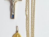 une croix, une médaille et un collier sur un fond blanc