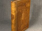 un vieux livre posé sur une table à côté d'un fond gris
