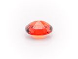an oval faceted red garnet stone on a white background