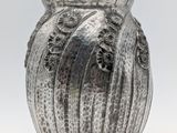 a silver vase that is sitting on a table