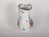 a small white vase with a floral design on it
