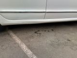 the side of a white car parked in a parking lot