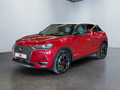 Un SUV rouge est garé dans une grande pièce