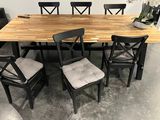une table en bois avec quatre chaises et un vase posé dessus