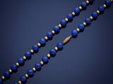 a gold and lapis beaded necklace with blue glass beads