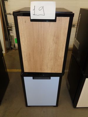 a refrigerator with a sign on top of it in a room