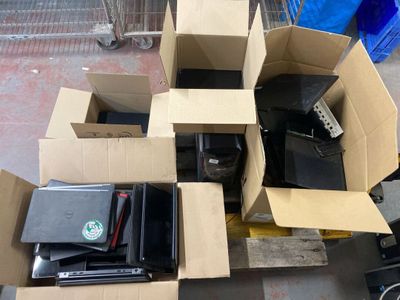 un tas de matériel électronique dans un carton posé sur une palette