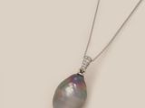 a black pearl and diamond pendant on a silver chain