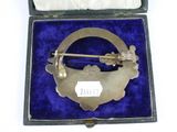 an antique silver plated broochee in a blue velvet case