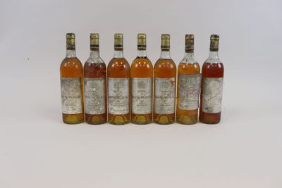 six bouteilles de whisky alignées sur une surface blanche