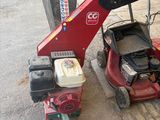 a red lawn mower sitting on the side of the road