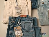 three pairs of jeans with tags on them sitting next to each other