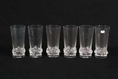 six clear glass shot glasses lined up against a black background