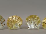 three glass figurines of leaves on a white surface