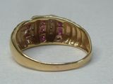Gros plan sur une bague en or ornée de pierres roses