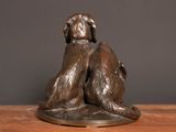 a bronze statue of two dogs sitting on a wooden table