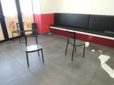 a room with two black chairs and a piano in it
