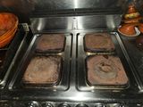 four pans of brownies sitting on a stove top