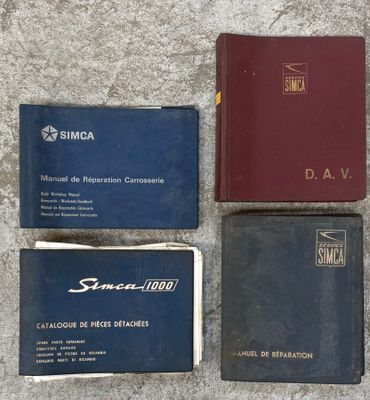 Plusieurs livres sont alignés sur une surface en béton ; parmi eux, l'un est rouge et l'autre bleu.