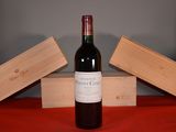 une bouteille de vin posée sur une table, à côté de deux caisses en bois