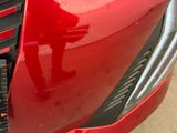 a close up of a red car ' s front bumper