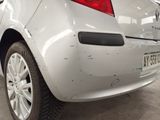 the rear end of a white car with a denting bumper