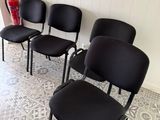 quatre chaises noires alignées dans une pièce