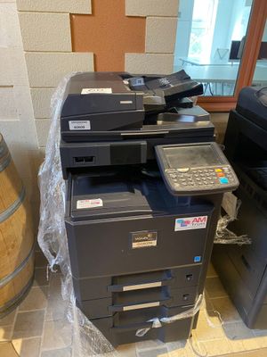 a printer that is sitting on the floor next to a barrel